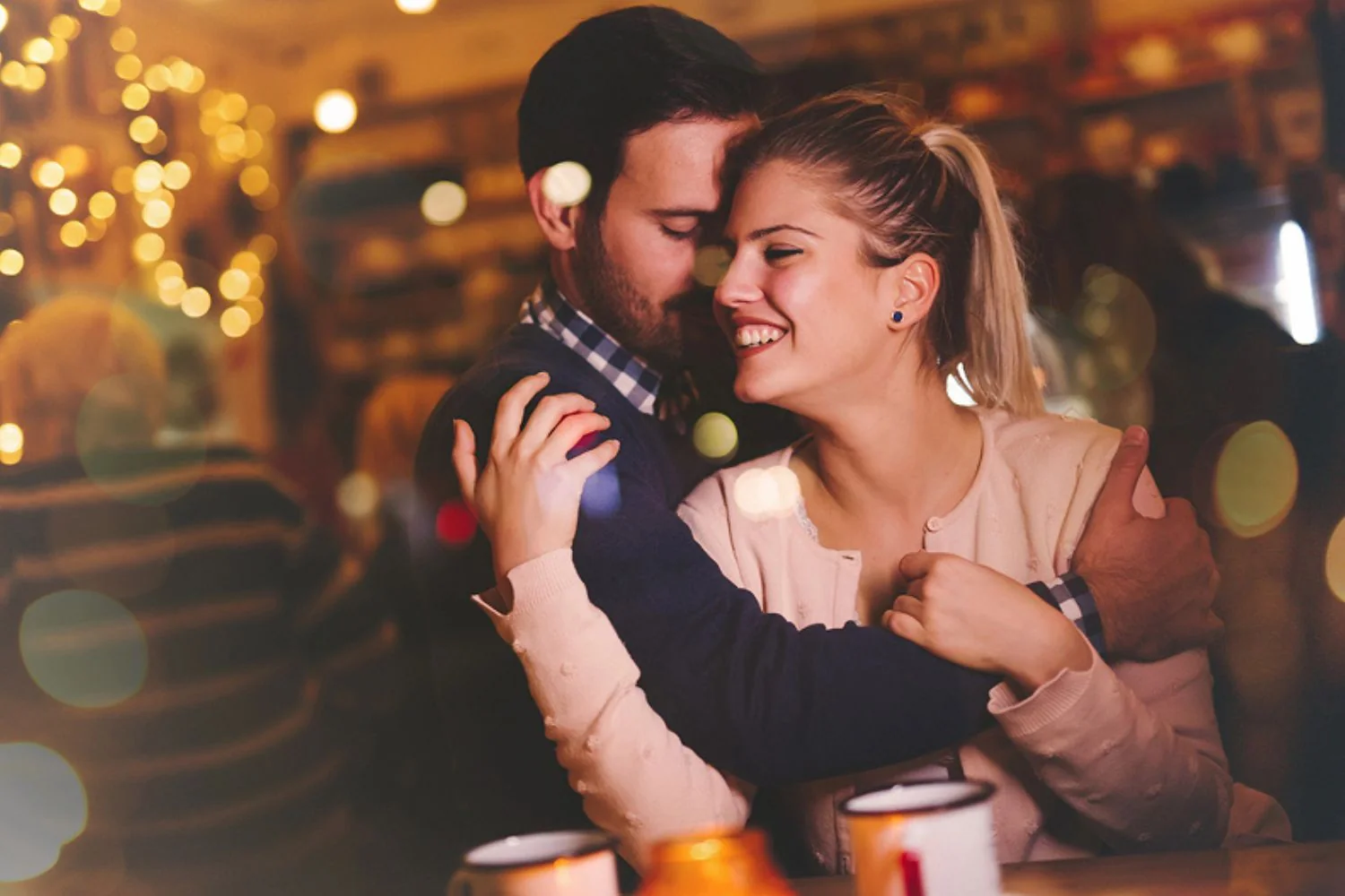 A couple laughing together in a warmly lit bar