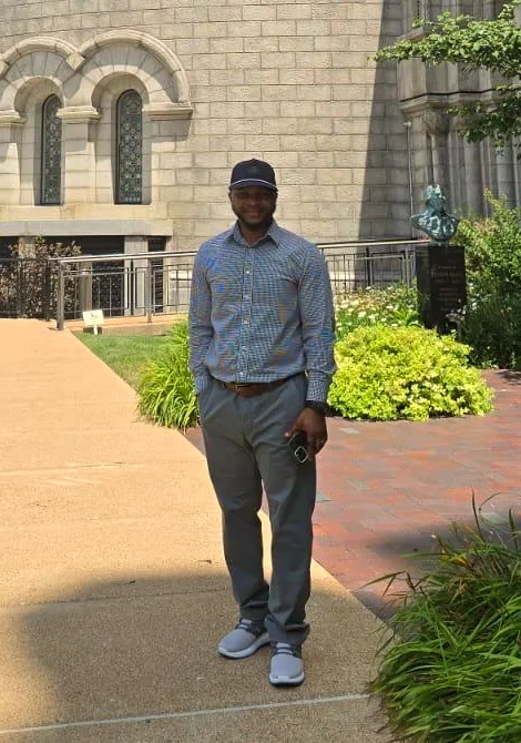 Samuel, standing in front of stone arches